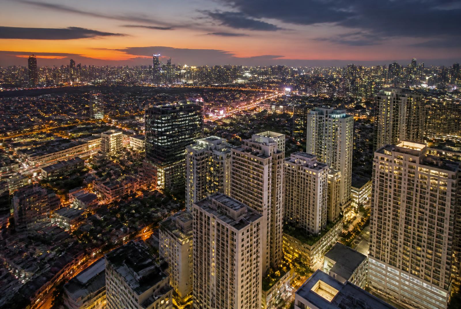 Aerial view of the Metro Manila skyline at dusk where Montaire manages vacation rentals and short-term rental properties
